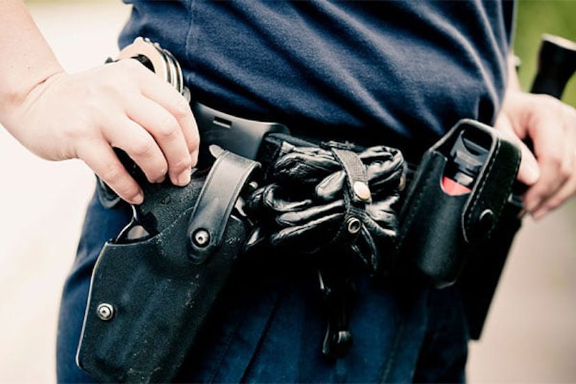 Midsection of a police officer wearing equipment belt