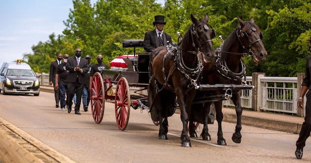 A horse drawn carriage carrying the body of civil rights icon, former US Rep. John Lewis (D-GA) cros...