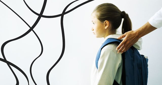 Woman's hand on shoulder of girl with backpack