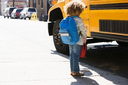 boy standing near school bus