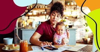 Close up of a mother using a phone with her daughter while having breakfast and doing bills