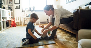 Mother teaching son to tie shoelace