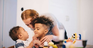 mother embracing sons at home