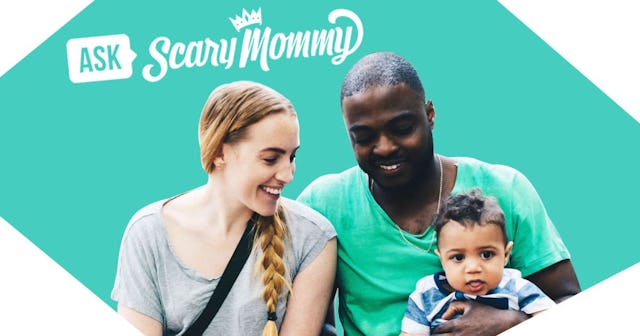 Smiling parents sitting with toddler at park