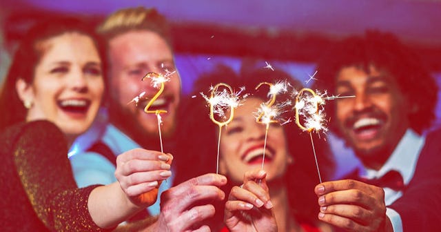 Smiling people holding sparklers