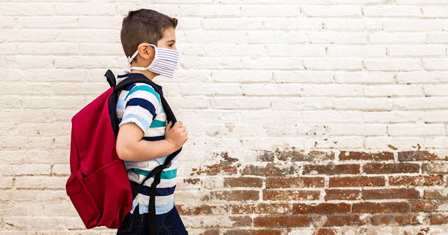 Little boy going to school with protective mask