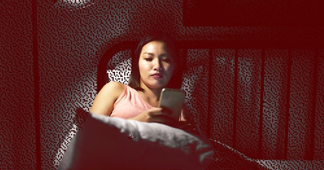 Woman texting in bed late at night