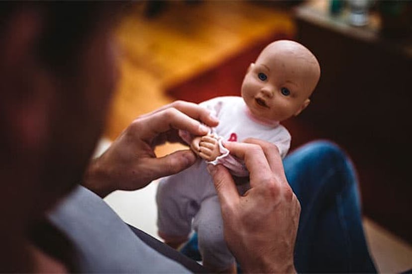 Close-Up Of Man Playing With Doll At Home