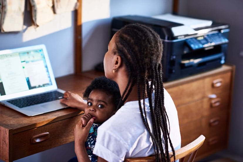 Mother with baby son working on laptop