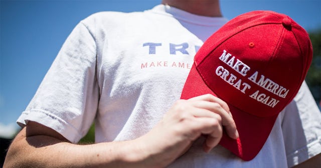 A supporter of U.S. President Donald Trump holds a Make America Great Again Hat over his heart durin...
