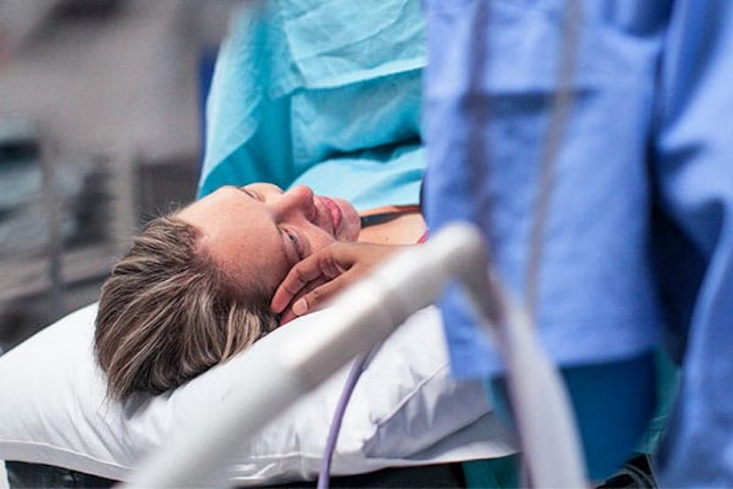 pregnant woman lays on the operating table moments before a caesarean section
