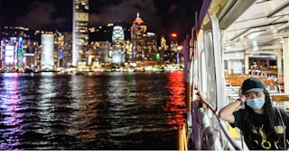 A woman wearing a face mask takes a Star Ferry in Victoria Harbour from Kowloon side to Hong Kong Is...