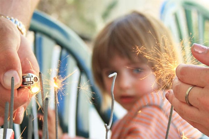 girl watching lighting of sparklers