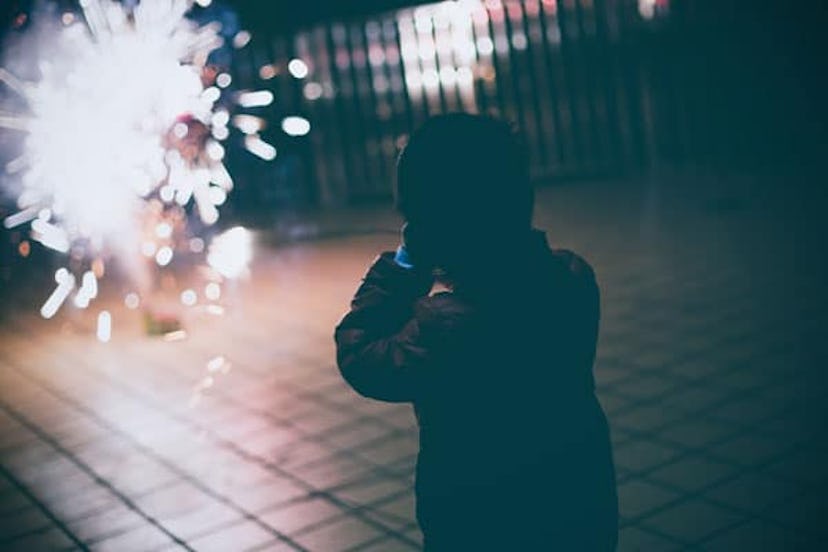 Boy looking fireworks with hands covering ears