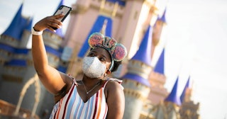 a guest stops to take a selfie at Magic Kingdom Park at Walt Disney World Resort on July 11, 2020 in...