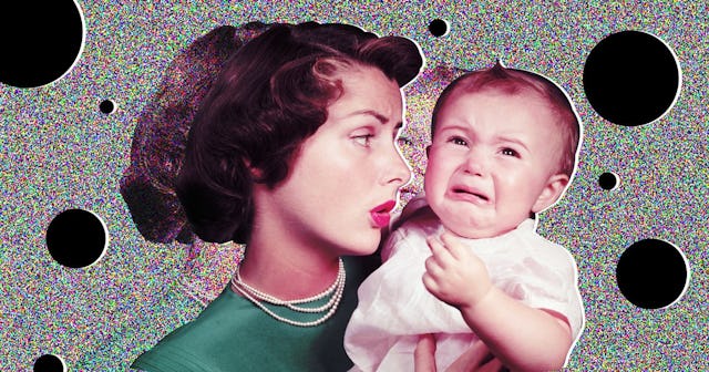 Woman wearing green dress and pearls holding a crying baby in a pink dres