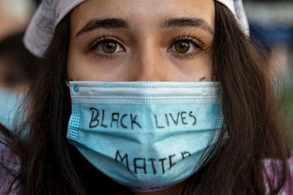 demonstrator wears a protective mask reading 'Black Lives Matter' during Black Lives Matter protest ...