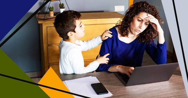 Boy Talking With Stressed Mother Using Laptop On Table At Home