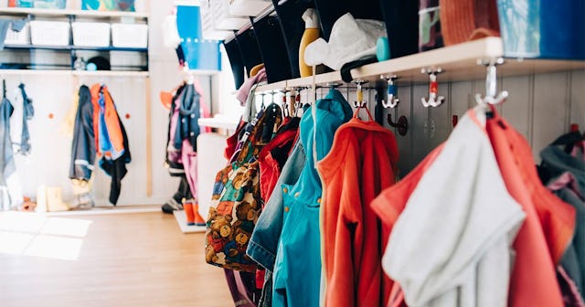 Various clothes hanging from hooks in cloakroom at preschool