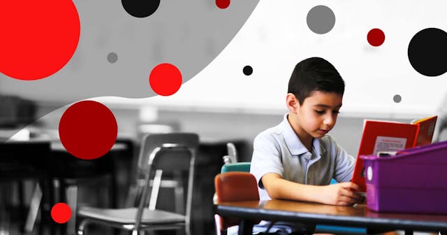 Six year old boy reads alone in class.