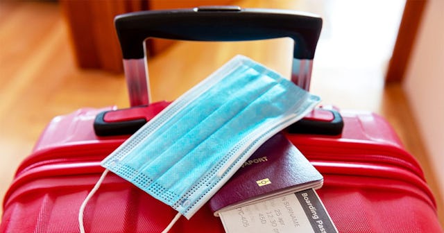 Face protection mask over passport and boarding ticket