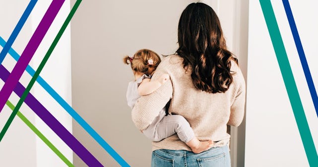 Mother carrying baby daughter through hall doorway, rear view