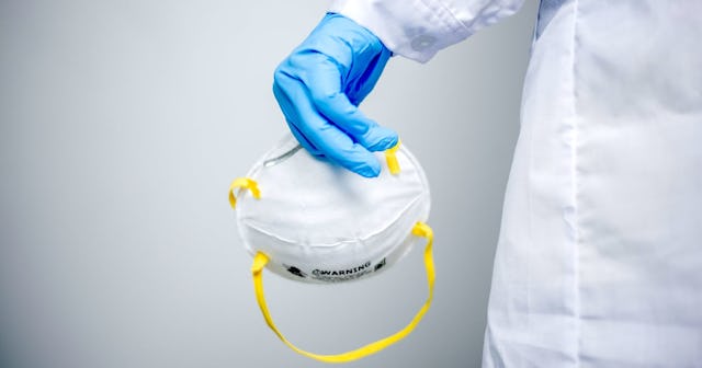 Doctor holds mask in hand
