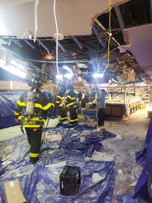 Firefighters walking through the rubble of Breadberry store with a collapsed ceiling 