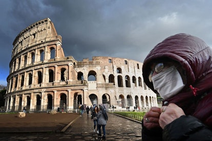 A man wearing a protective mask passes by the Coliseum in Rome on March 7, 2020 amid fear of Covid-1...