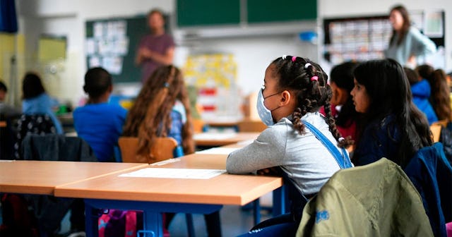 A girl wears a face mask as students sit in a classroom of the Petri primary school in Dortmund, wes...