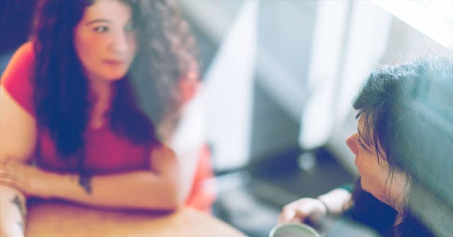 A birth mother of a teenage child and his stepmother having a conversation over a coffee