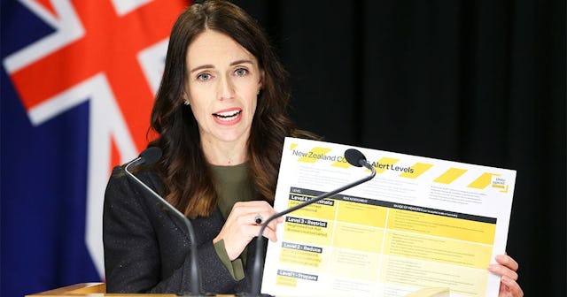 Prime Minister Jacinda Ardern holds up informationon COVID-19 alert levels