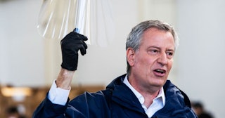 New York Mayor Bill de Blasio holds a face shield as he speaks to the media during a visit to the Br...