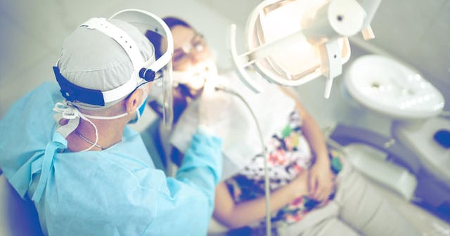 dentist examining the teeth of a young woman