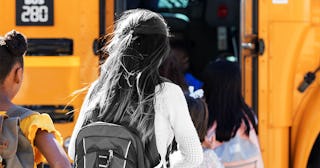 Children board a school bus in a line