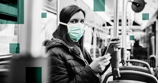 Young woman is driving in a bus and wearing a protection mask from virus and holding smart phone