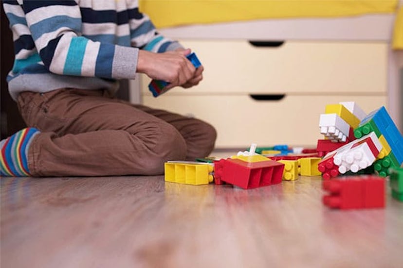 a little boy playing with colored cubes on the floor