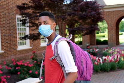 teenager wearing backpack and facial mask to protect himself from Coronavirus