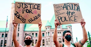 Protesters hold signs outside at Hennepin County Government Plaza, during a demonstration against po...