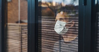 Study Shows Women Produce A Stronger Immune Response To COVID: Man with mask looking out of window