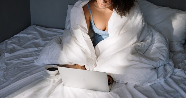 skype sex, woman in bed with laptop covered in blanket