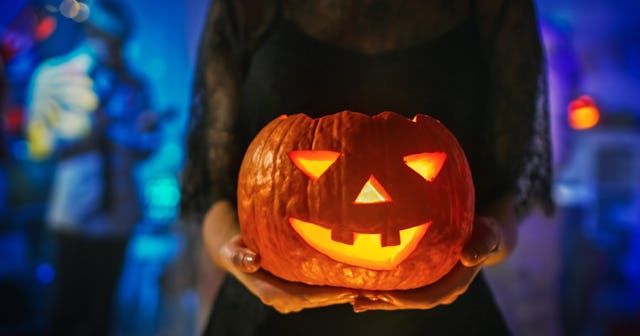 Girl at party holding jack-o-lantern — college halloween costumes.