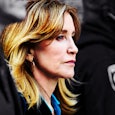 Felicity Huffman is standing between a lawyer and policeman in court 