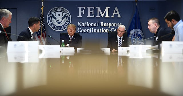 US President Donald Trump(C) listens as US Vice President Mike Pence(R) attend a briefing for Hurric...