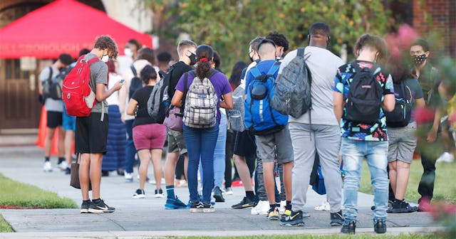 Students at Hillsborough High School wait in line to have temperature checked before entering the bu...