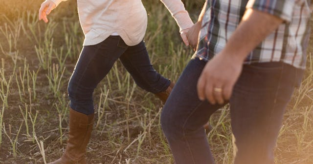 couples therapy vs marriage counseling, Couple holding hands walking through a field at dusk