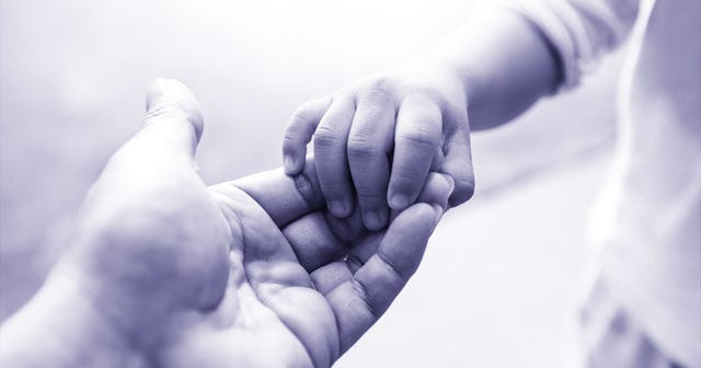 Newborn's hand holding an adult hand by the finger 