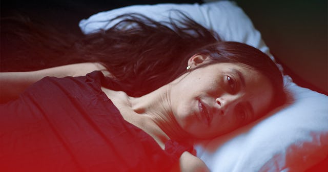 Younger woman experiencing anxiety while laying in bed 
