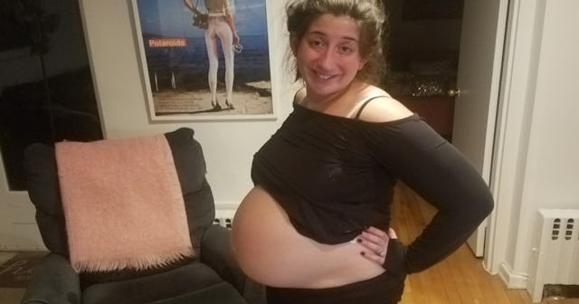 A pregnant woman with an exposed belly posing for a photo