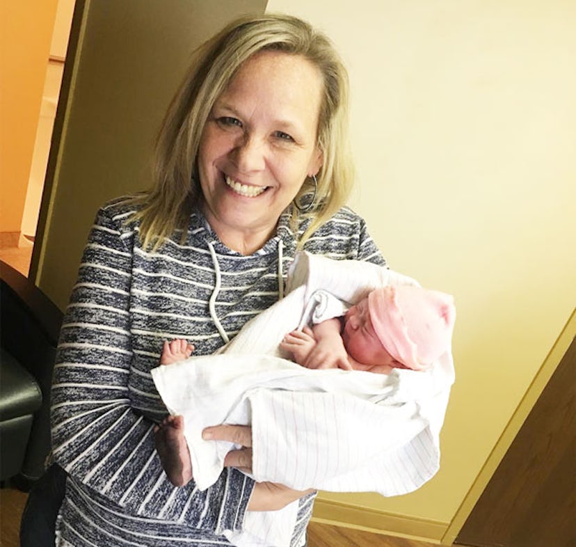 Candace Smith holding her newborn grandchild and smiling